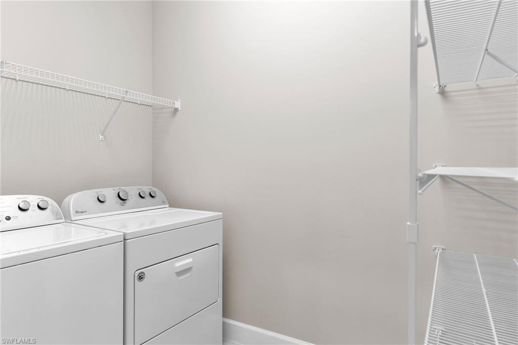 Washroom featuring independent washer and dryer and baseboards