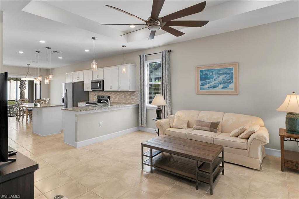 Living room featuring light tile patterned floors, a ceiling fan, and recessed lighting