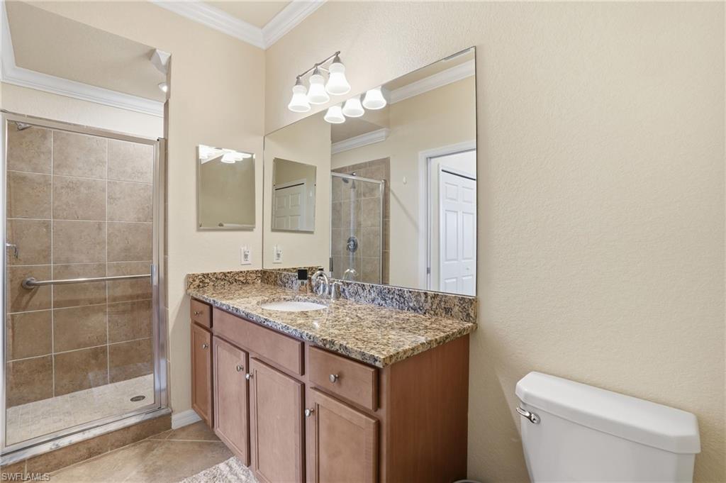 Full bathroom featuring ornamental molding, a stall shower, vanity, and light tile patterned flooring
