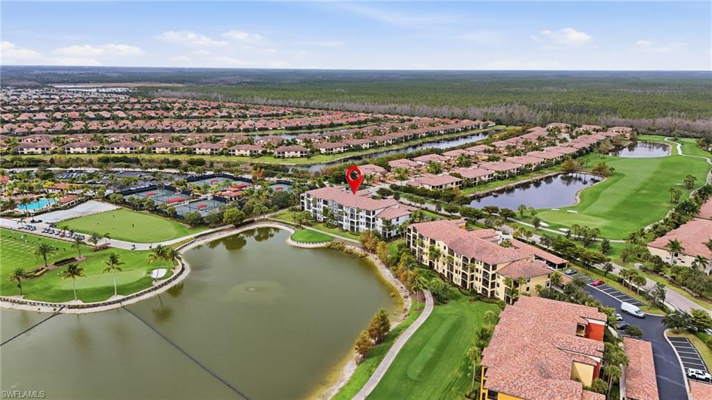 Aerial view of property's location featuring a golf club, a nearby body of water, and nearby suburban area