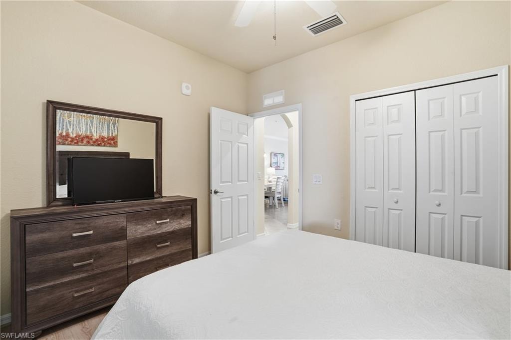Bedroom featuring arched walkways, a ceiling fan, and a closet