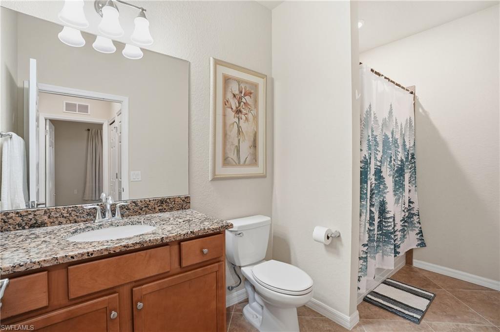 Full bathroom with a shower with curtain, vanity, and light tile patterned flooring