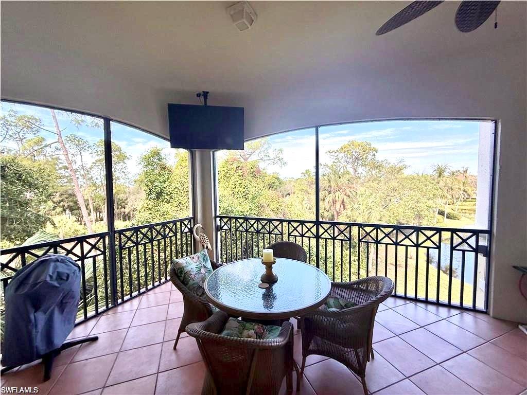 Balcony with grilling area, outdoor dining space, and a ceiling fan