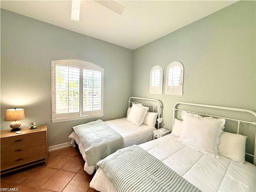 Bedroom featuring tile patterned flooring, multiple windows, and a ceiling fan