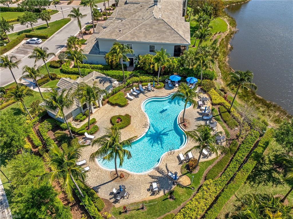 Drone / aerial view of a pool area and a large body of water