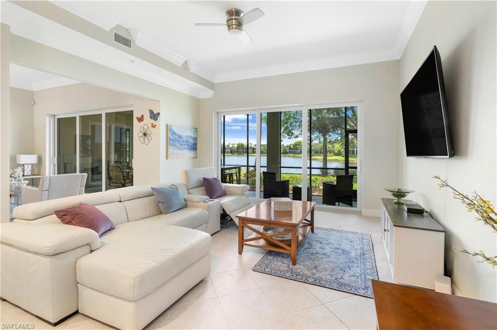 Living area featuring ornamental molding, light tile patterned flooring, and ceiling fan