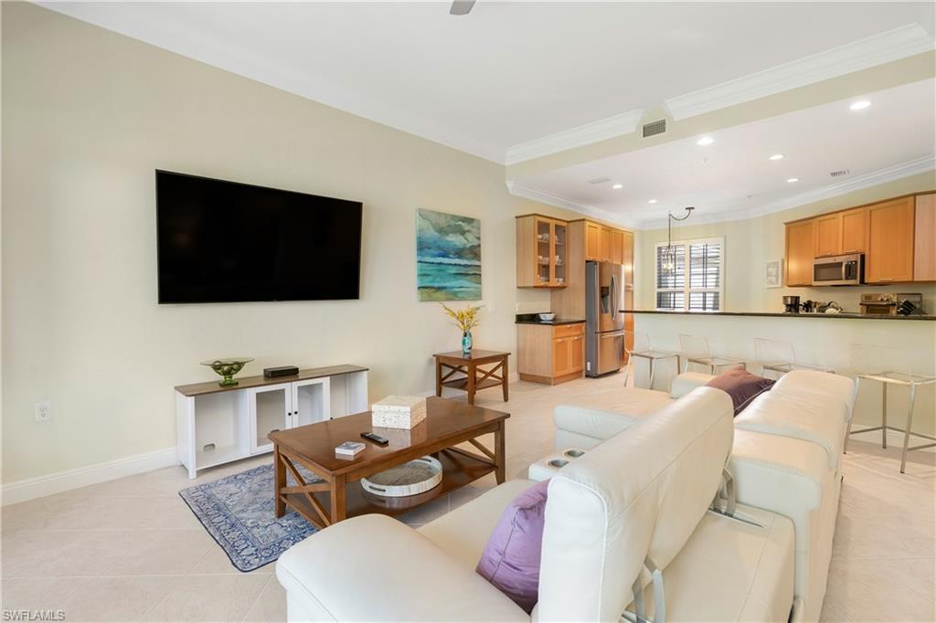 Living area featuring recessed lighting, light tile patterned flooring, and crown molding