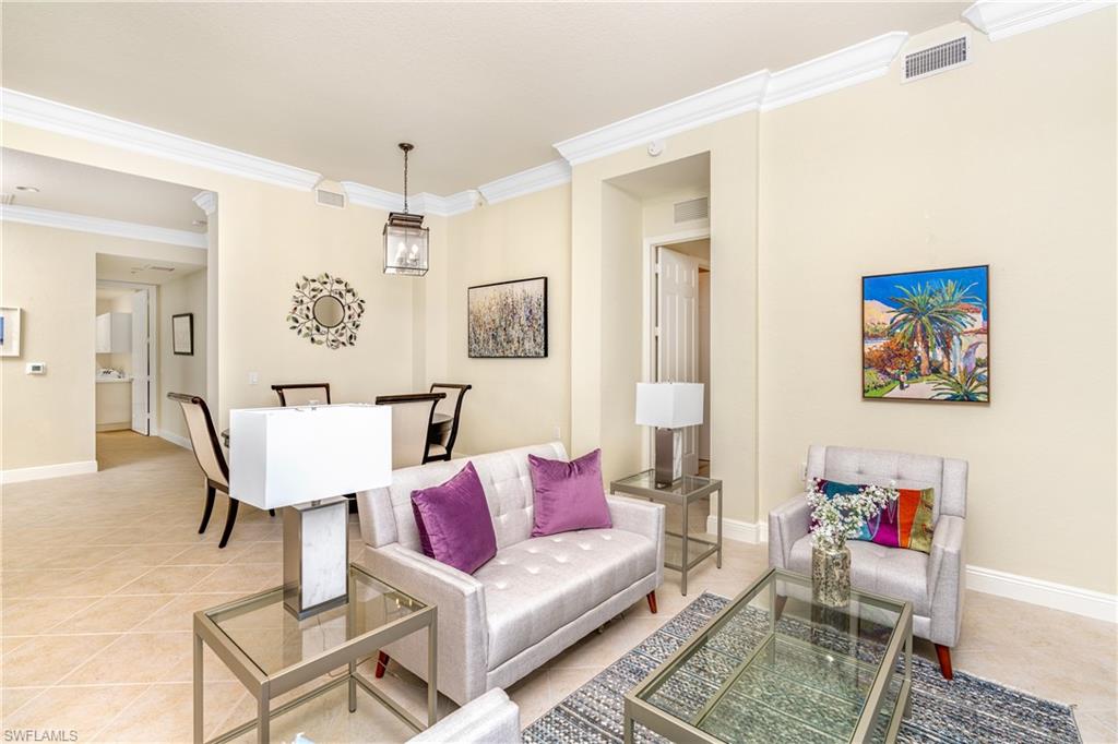 Living room featuring light tile patterned floors and ornamental molding