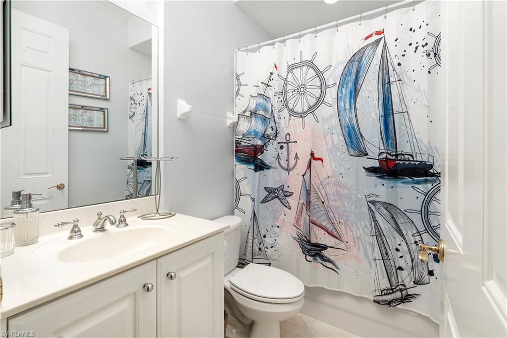 Full bath featuring vanity, tile patterned flooring, and shower / bath combo with shower curtain