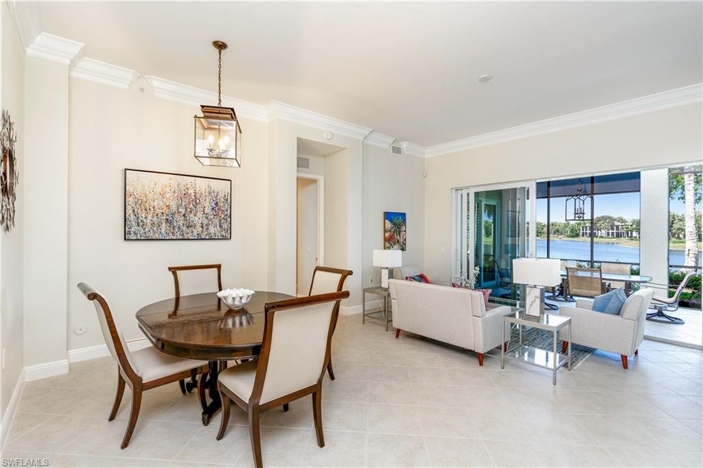 Dining space featuring a chandelier, ornamental molding, a water view, and light tile patterned floors
