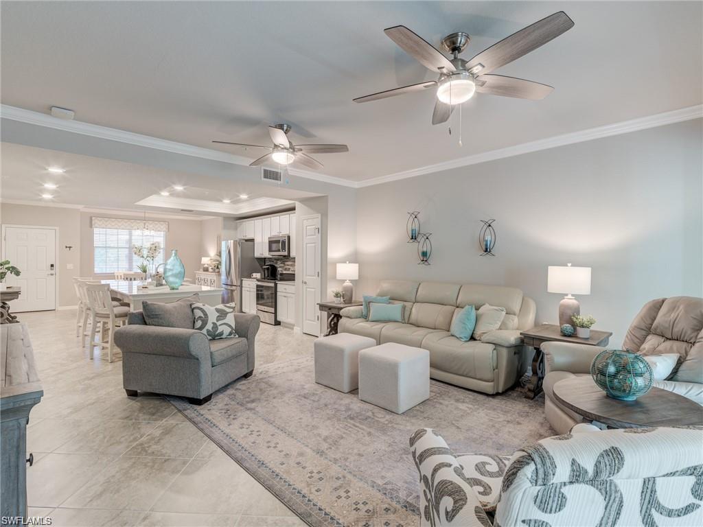 Living room featuring ceiling fan and ornamental molding
