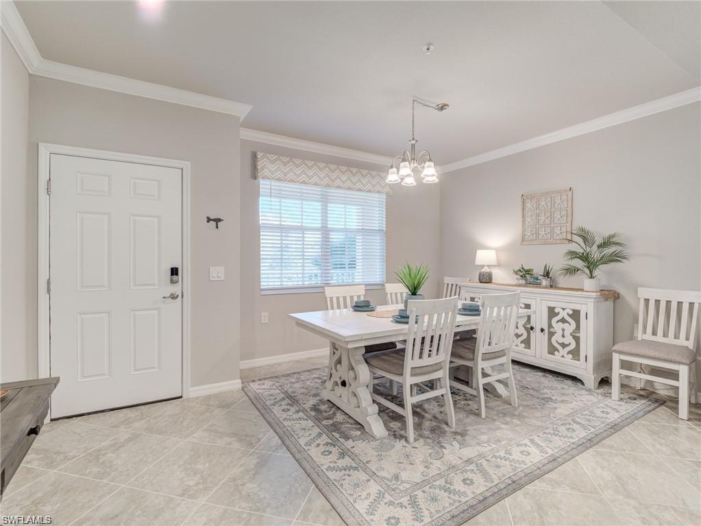 Tiled dining room with a notable chandelier and crown molding