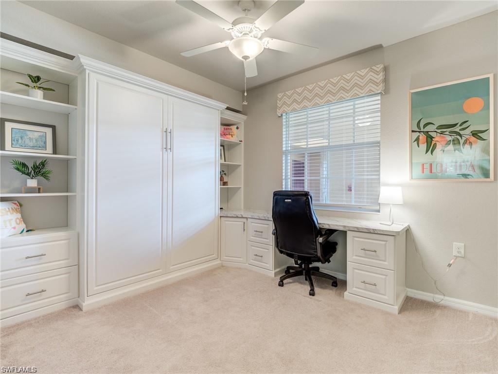 Carpeted office space featuring ceiling fan