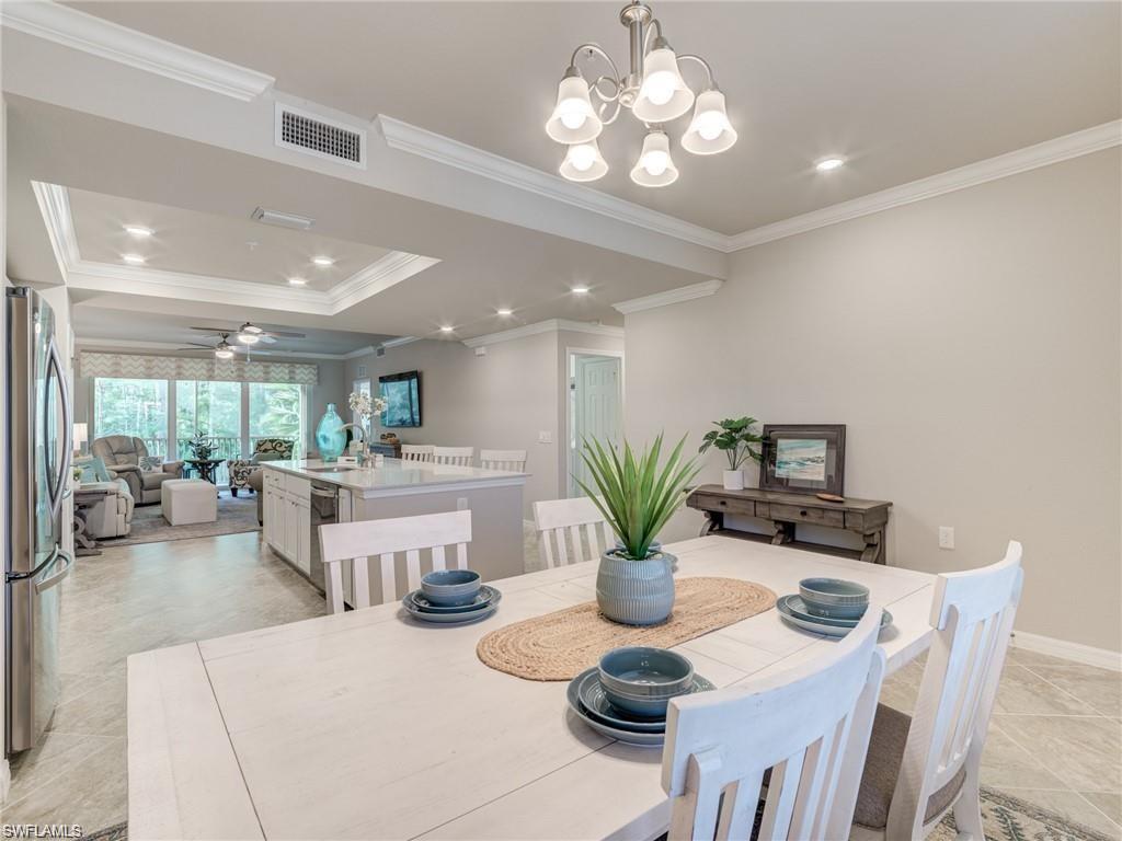 Dining room with crown molding and ceiling fan with notable chandelier