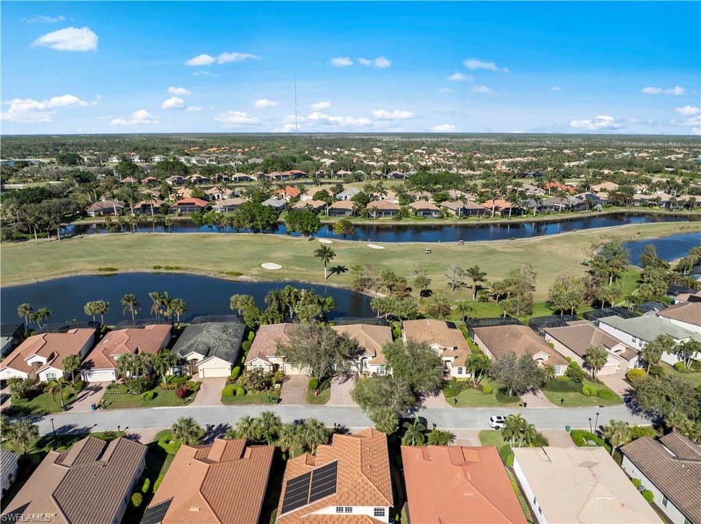 Aerial perspective of suburban area featuring a nearby body of water and a golf club