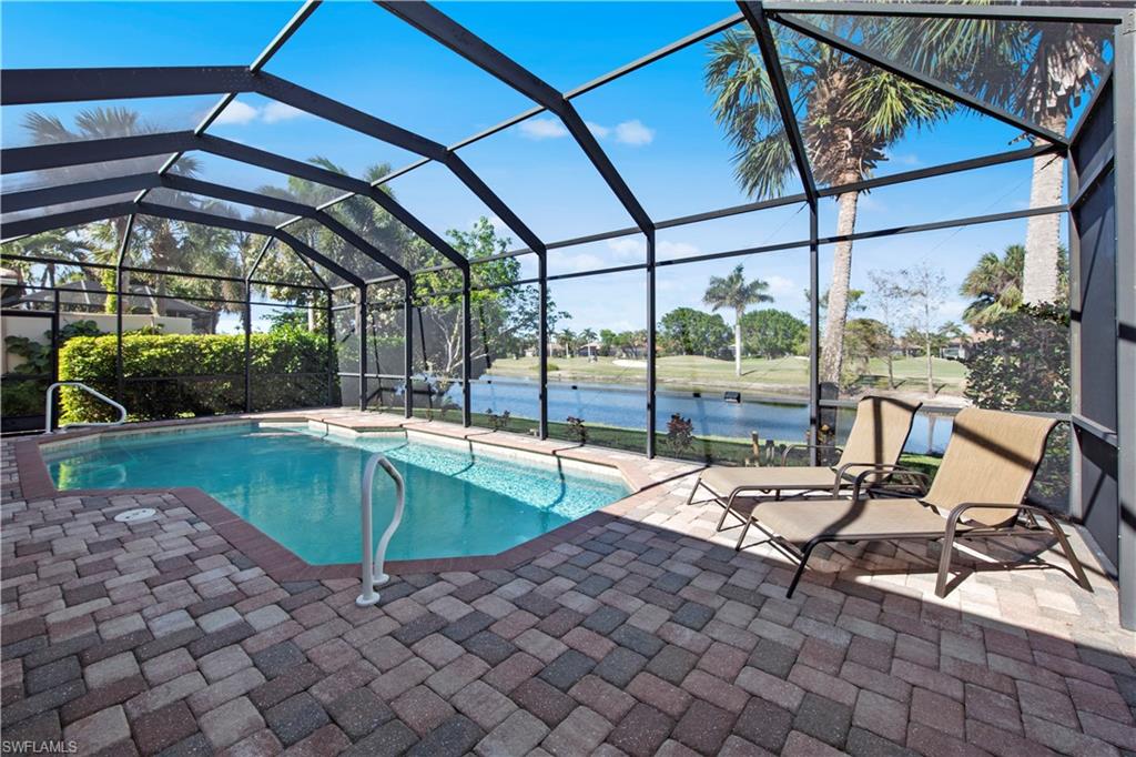 Swimming pool with a sunroom, a water view, a lanai, and a patio