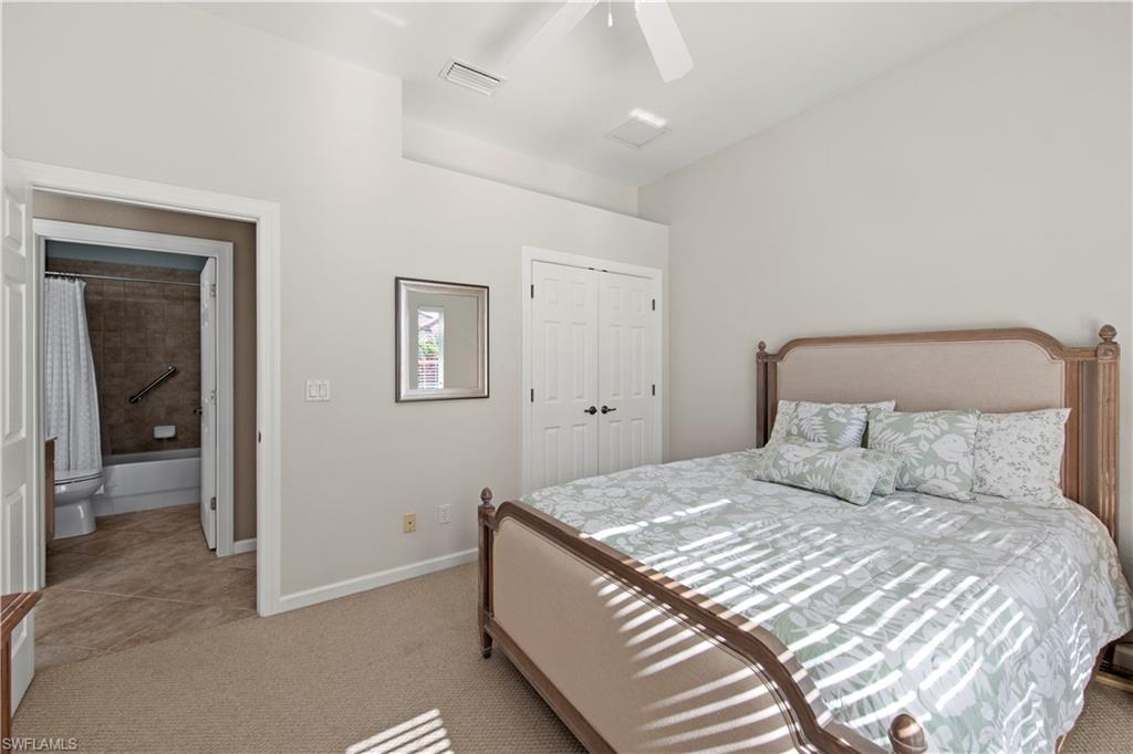 Bedroom featuring light carpet, a closet, a ceiling fan, and light tile patterned flooring