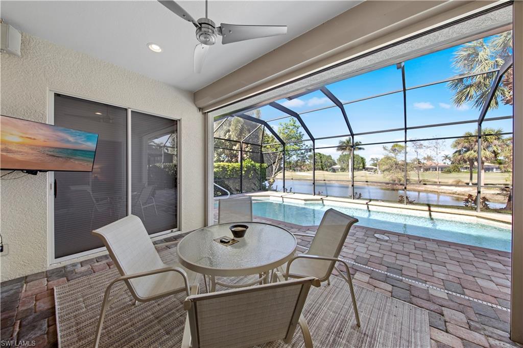 View of patio with an outdoor pool, a lanai, a water view, outdoor dining space, and a sunroom