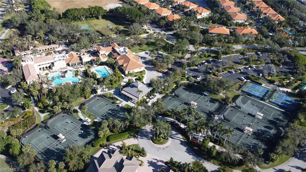 Aerial view of property and surrounding area featuring nearby suburban area and a pool