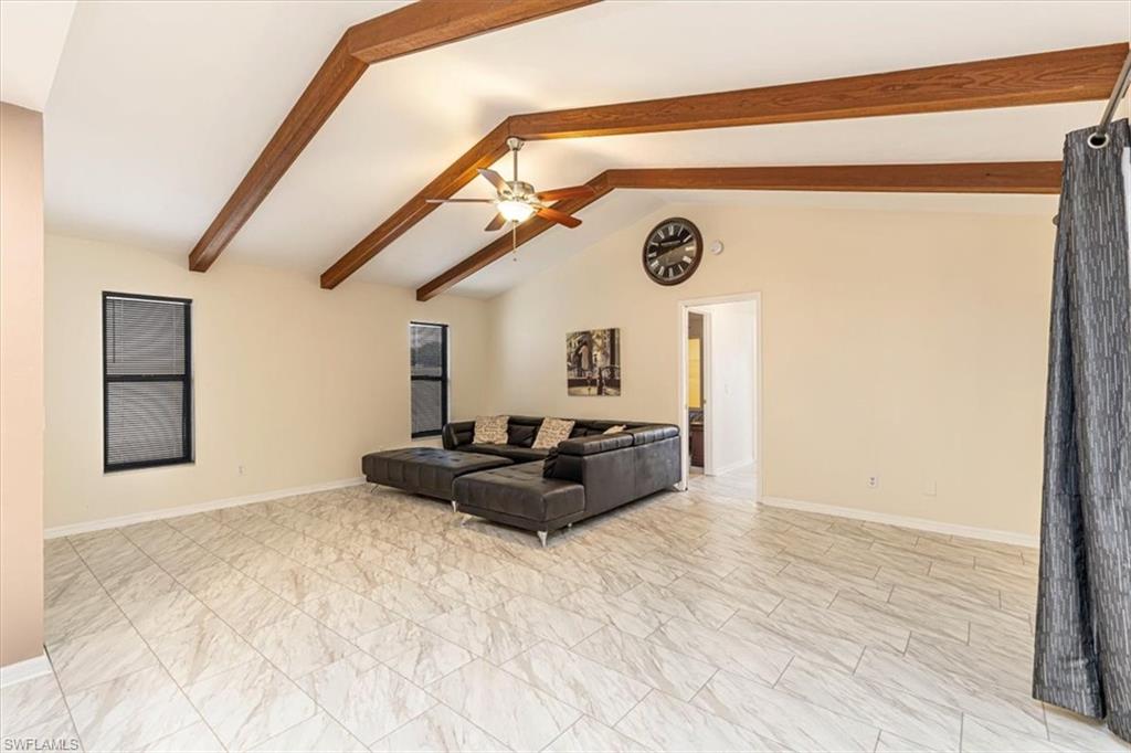 Living area featuring baseboards and ceiling fan