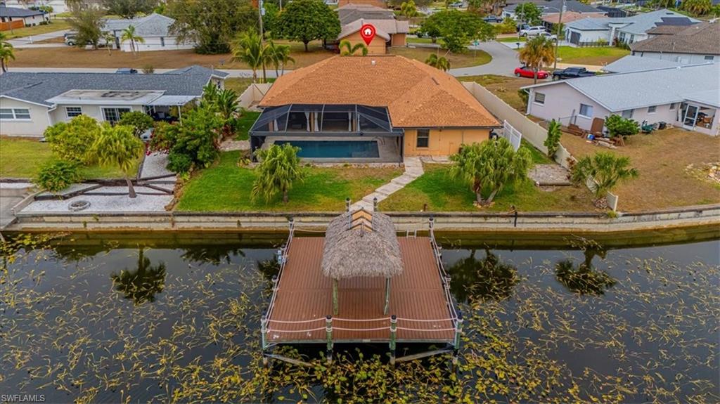 Back of property featuring a residential view, a water view, a lanai, and a sunroom
