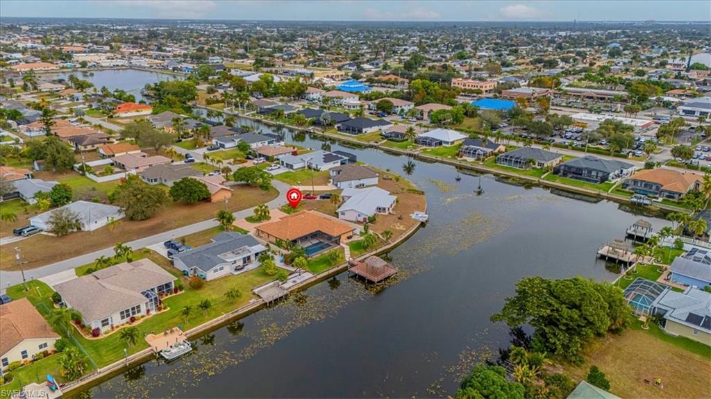 Aerial view of property and surrounding area with nearby suburban area and a large body of water