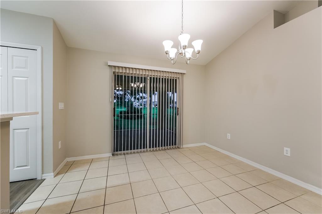 Empty room featuring a chandelier and light tile patterned flooring
