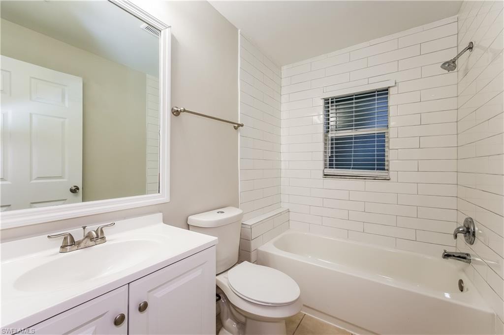 Bathroom featuring bathtub / shower combination, vanity, and tile patterned flooring