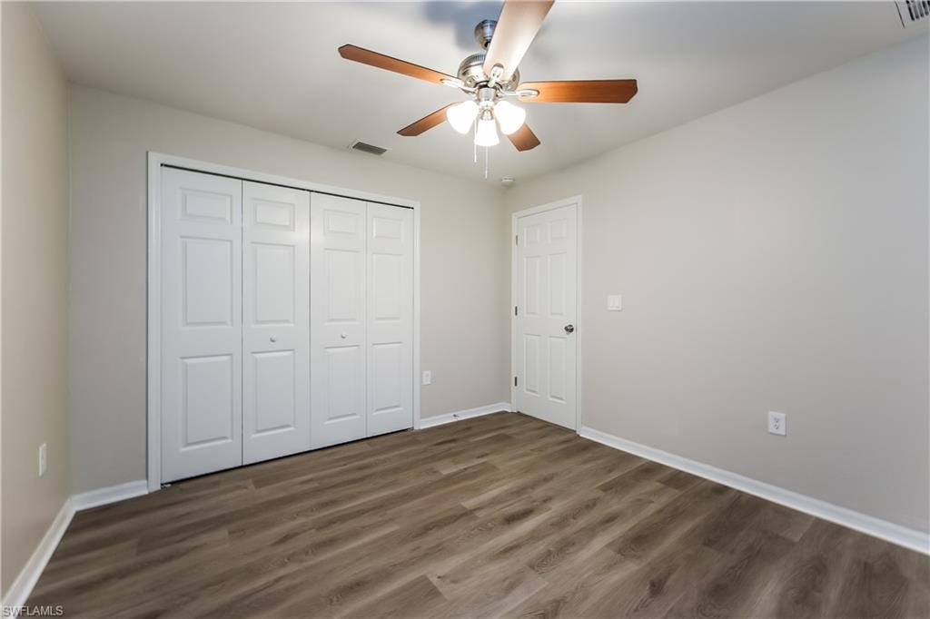 Unfurnished bedroom featuring dark wood-type flooring, ceiling fan, and a closet