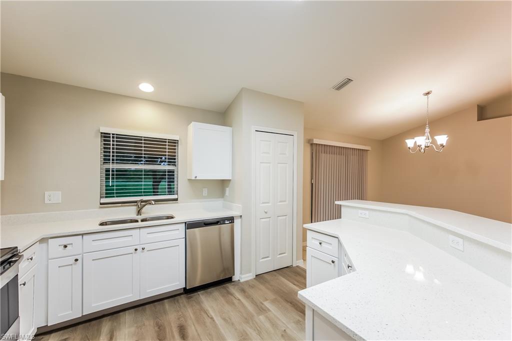 Kitchen with white cabinets, appliances with stainless steel finishes, pendant lighting, a chandelier, and recessed lighting