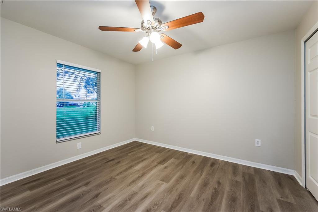 Spare room with dark wood finished floors and a ceiling fan