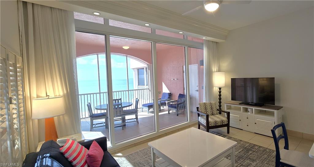 Living area with tile patterned floors and ceiling fan