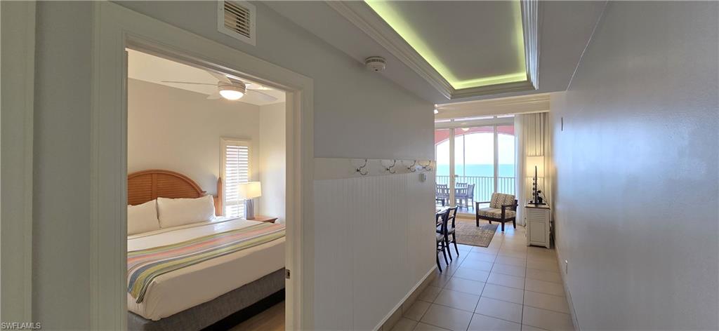 Hall featuring plenty of natural light, light tile patterned flooring, and a water view