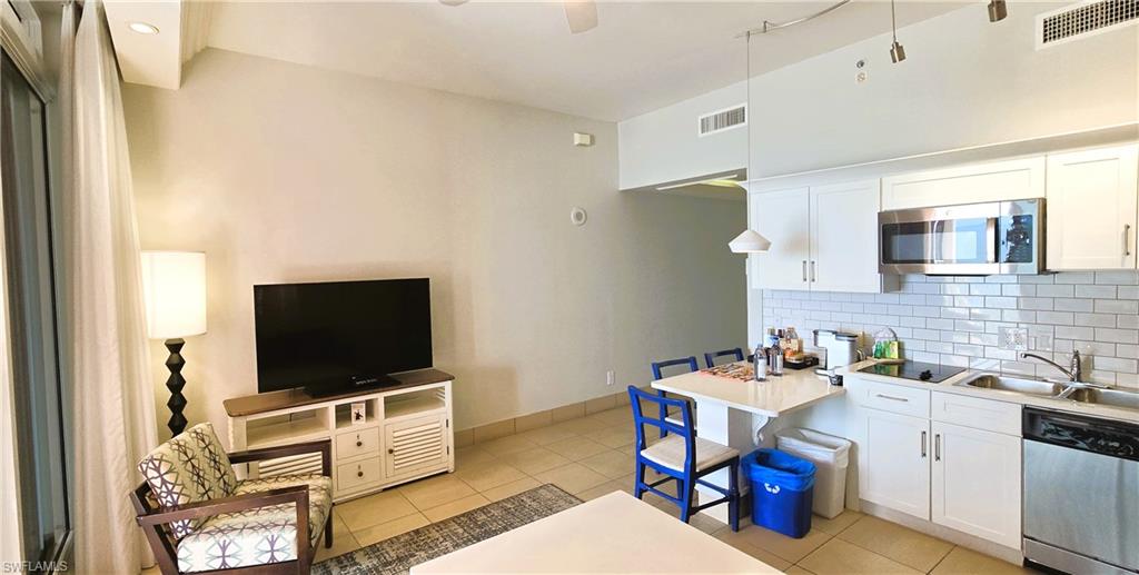 Kitchen featuring white cabinetry, stainless steel appliances, light countertops, and tasteful backsplash