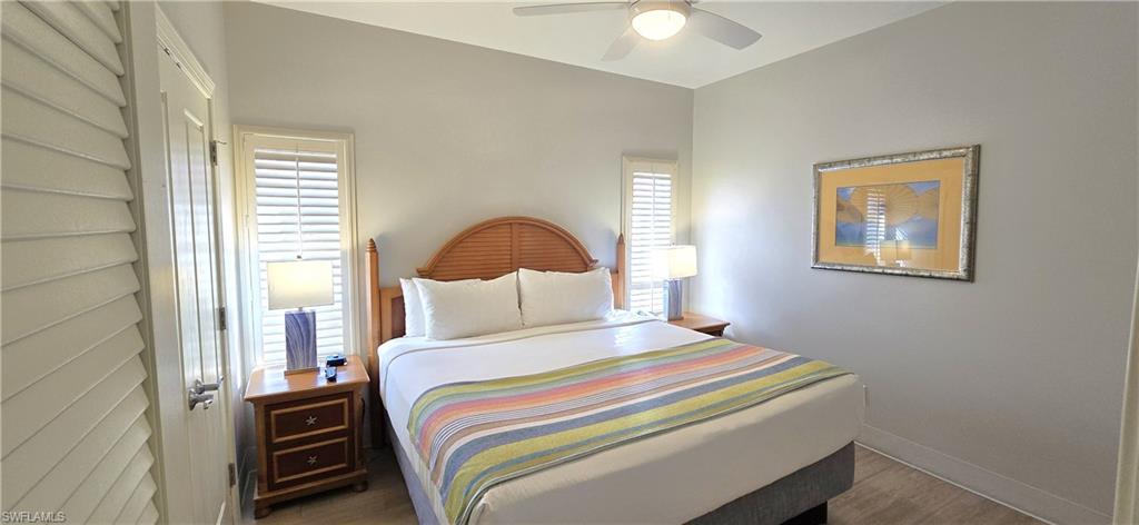 Bedroom with multiple windows, ceiling fan, and wood finished floors