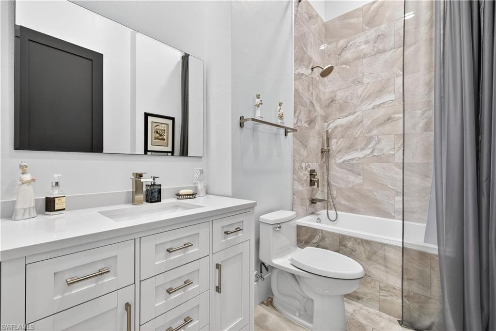 Full bathroom with tiled shower / bath and vanity
