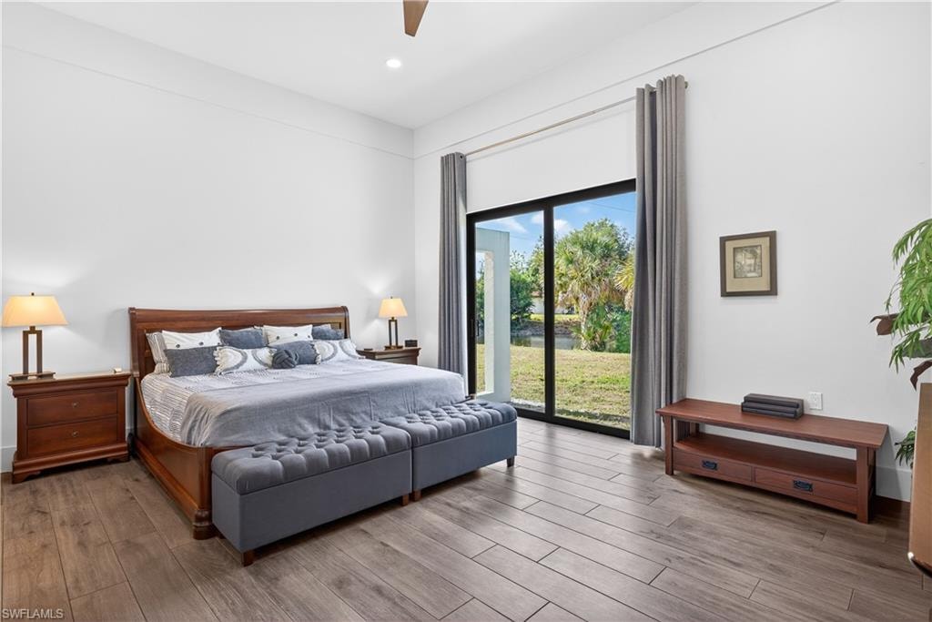 Bedroom featuring wood finished floors, access to exterior, and a ceiling fan