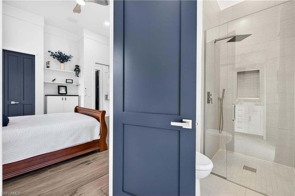 Bedroom with ensuite bathroom and a ceiling fan