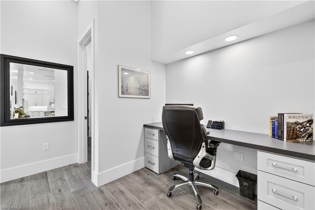 Office area with recessed lighting and light wood-style flooring