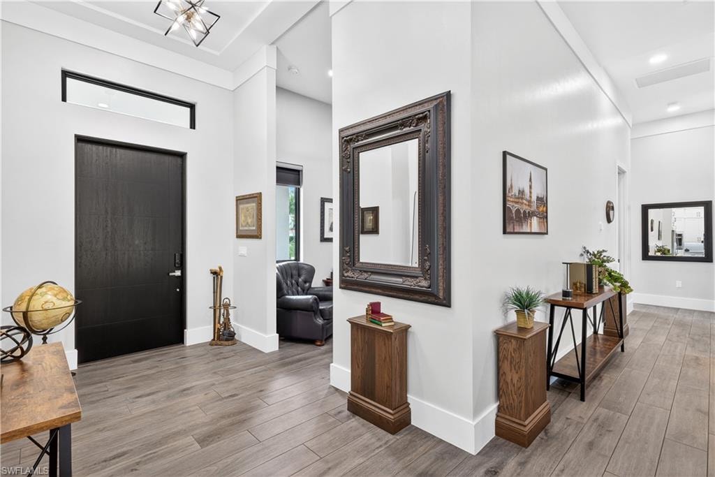 Entrance foyer with a towering ceiling and light wood-style floors