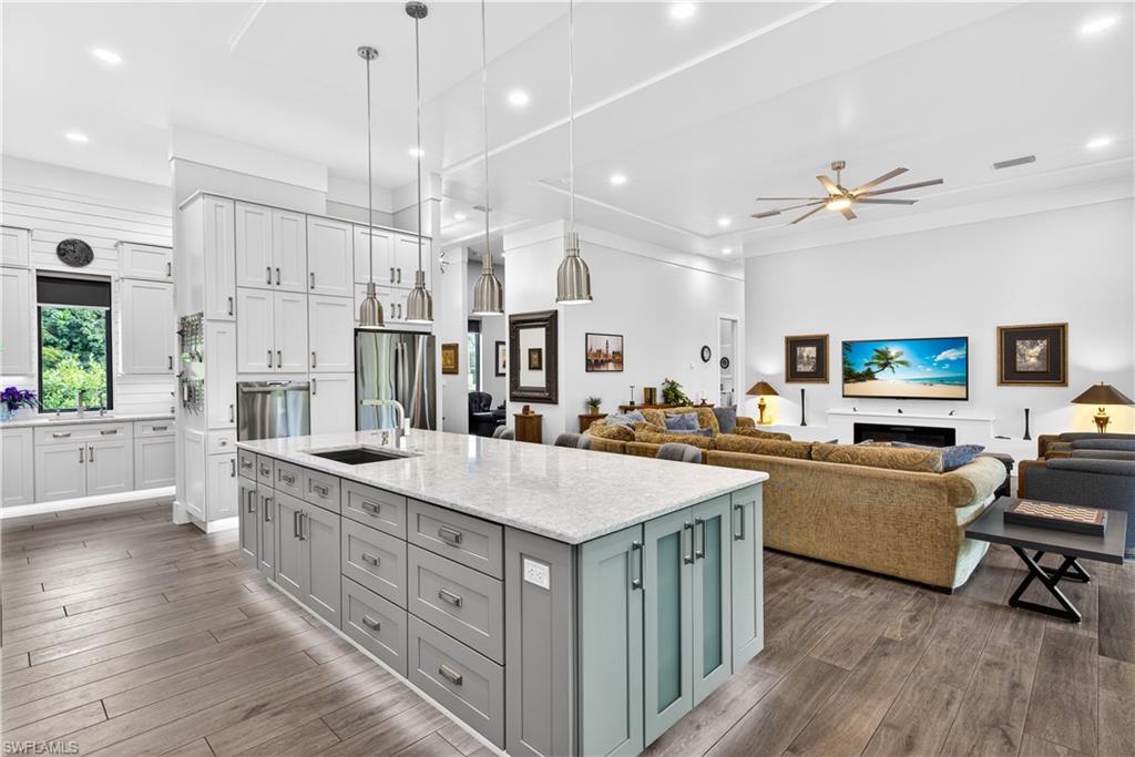 Kitchen with recessed lighting, a spacious island, white cabinets, pendant lighting, and a ceiling fan