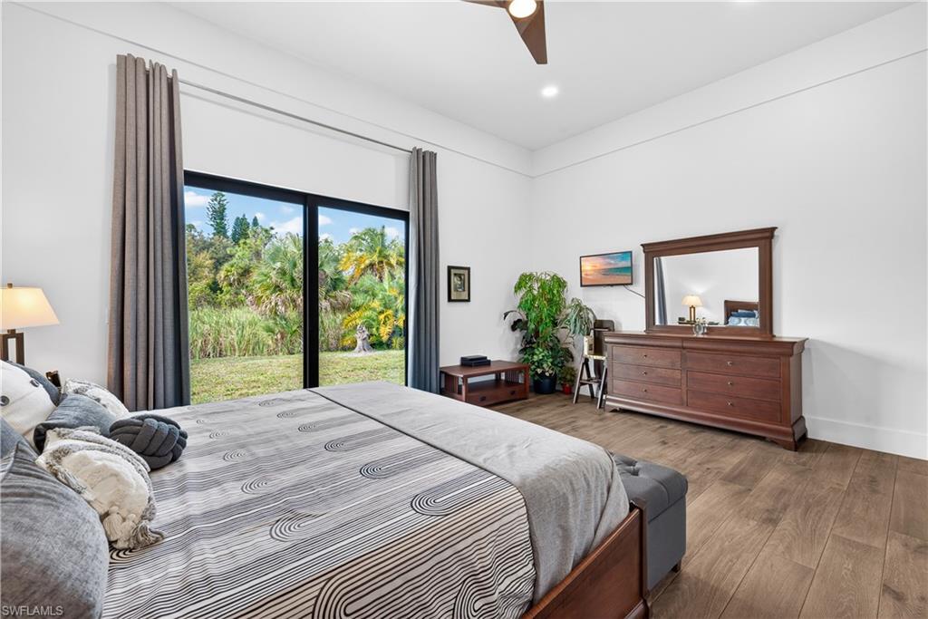 Bedroom featuring wood finished floors, access to outside, and a ceiling fan