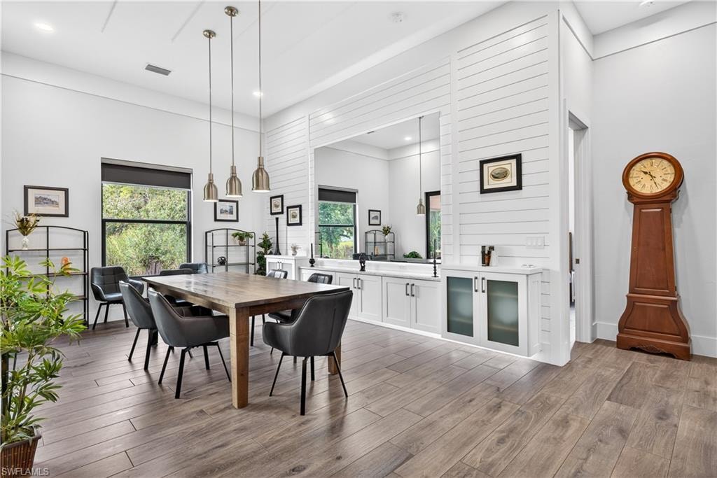 Dining area with dark wood-style floors and recessed lighting