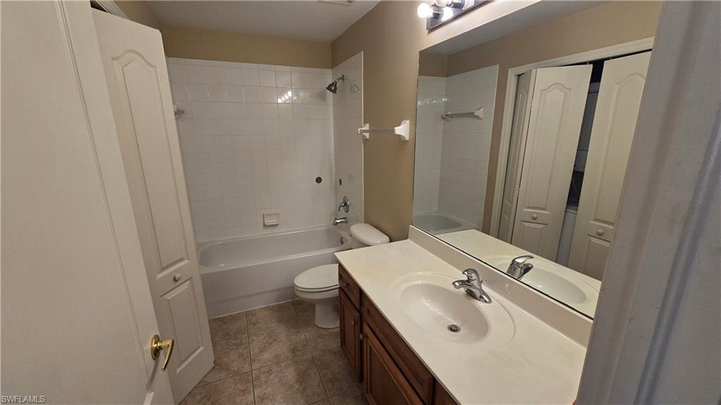 Bathroom with vanity, bathtub / shower combination, and a closet