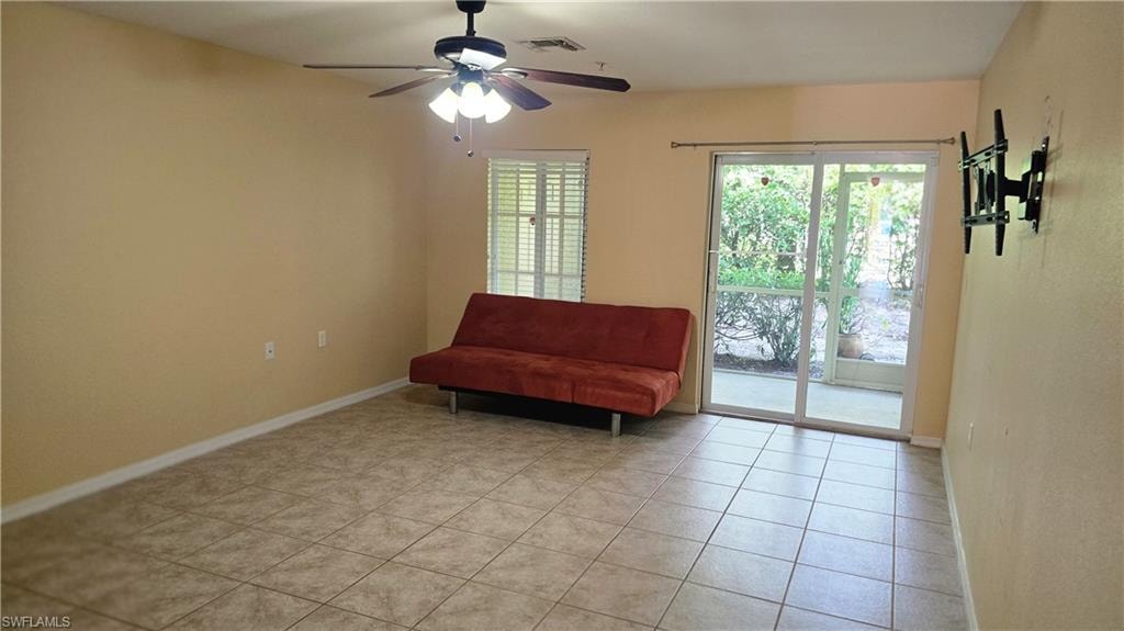 Living area featuring plenty of natural light, ceiling fan, and light tile patterned flooring