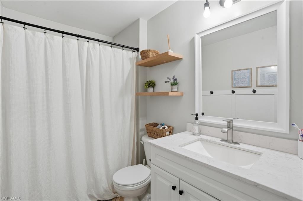 Full bathroom featuring curtained shower and vanity