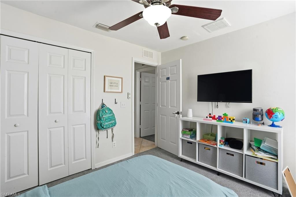 Carpeted bedroom featuring a closet and a ceiling fan