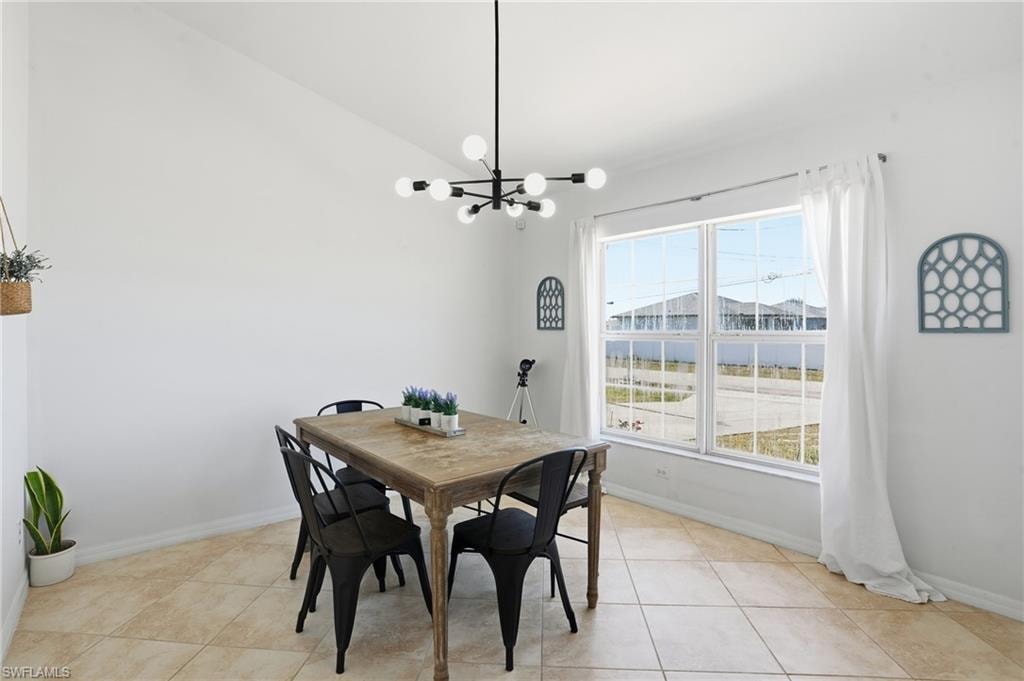 Dining space featuring vaulted ceiling, a chandelier, and light tile patterned floors