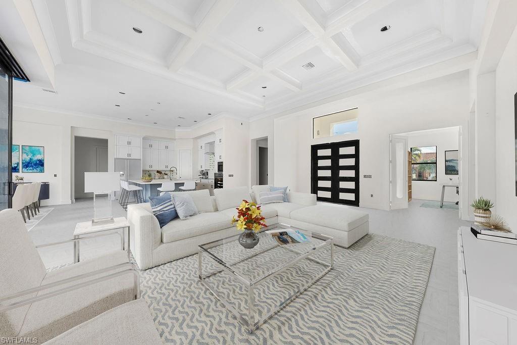 Living area with crown molding, coffered ceiling, beamed ceiling, and a high ceiling