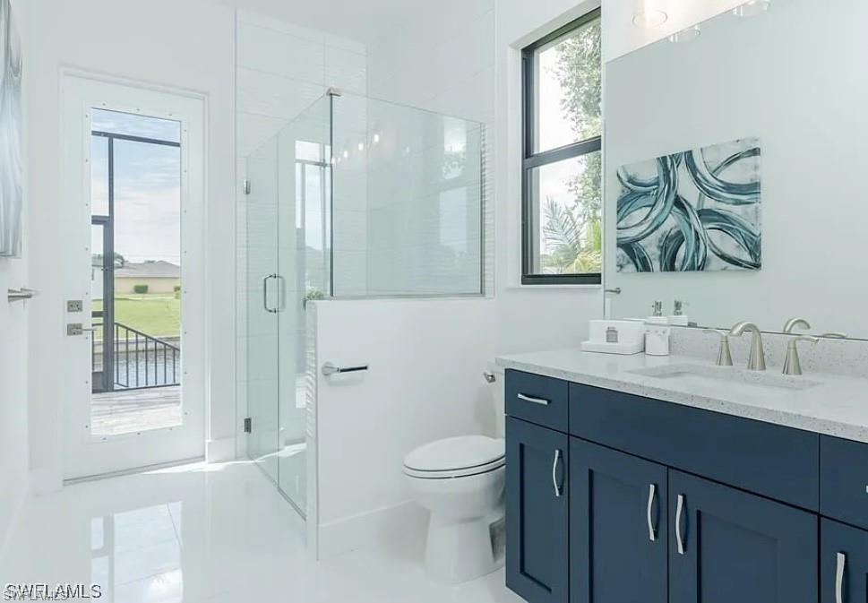Full bath with vanity, a stall shower, and light tile patterned floors